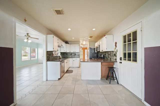 a kitchen with cabinets and chairs