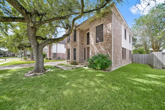 a view of a house with backyard and a tree