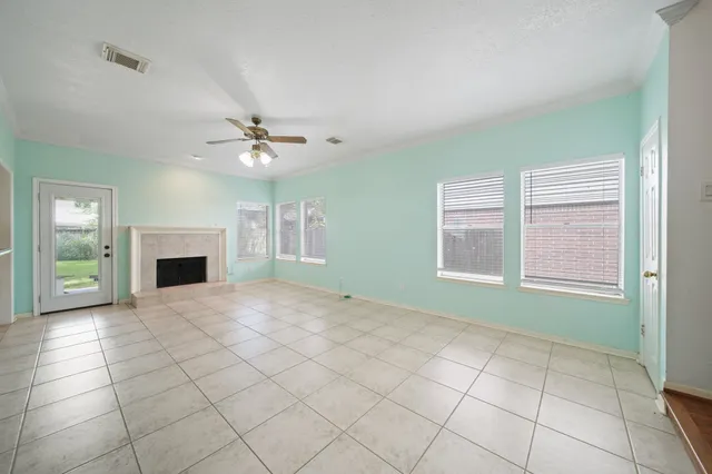 an empty room with windows and fireplace