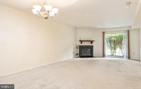 an empty room with a fireplace and a window