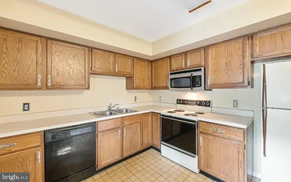 a kitchen with a sink stove top oven and refrigerator