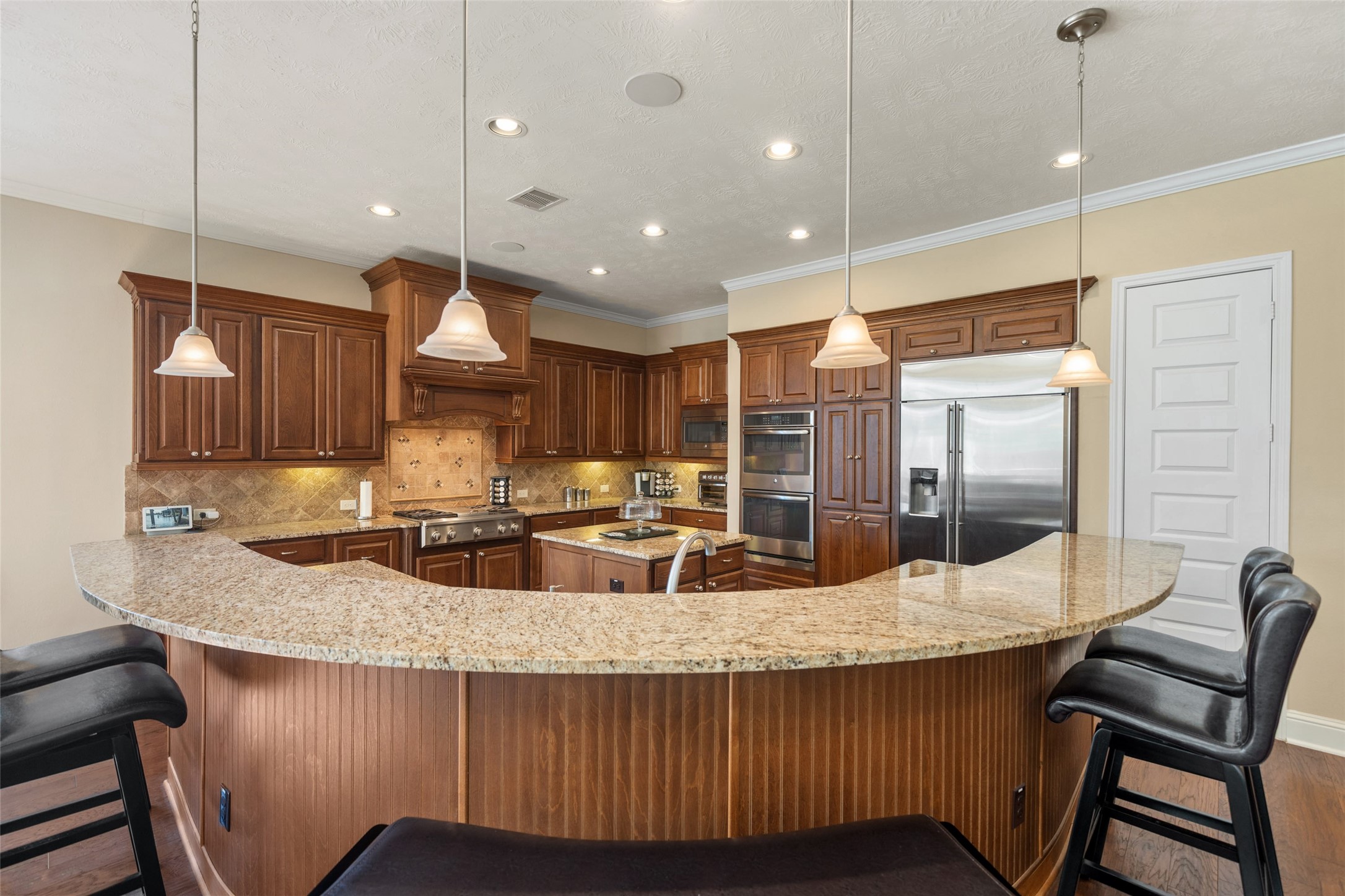 27626 South Colt Shadow Lane Spring, TX 77386 - Photo 11 of 50 a kitchen with center island wooden floor and stainless steel appliances