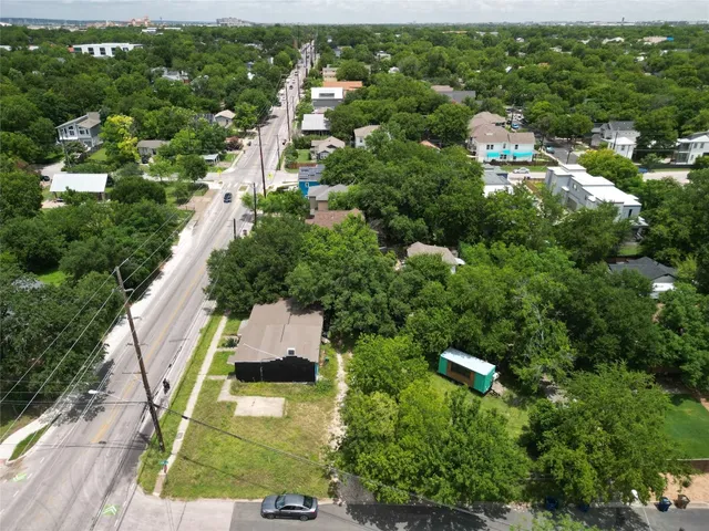an aerial view of residential houses with outdoor space and trees
