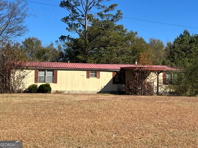 a view of a house with backyard and trees