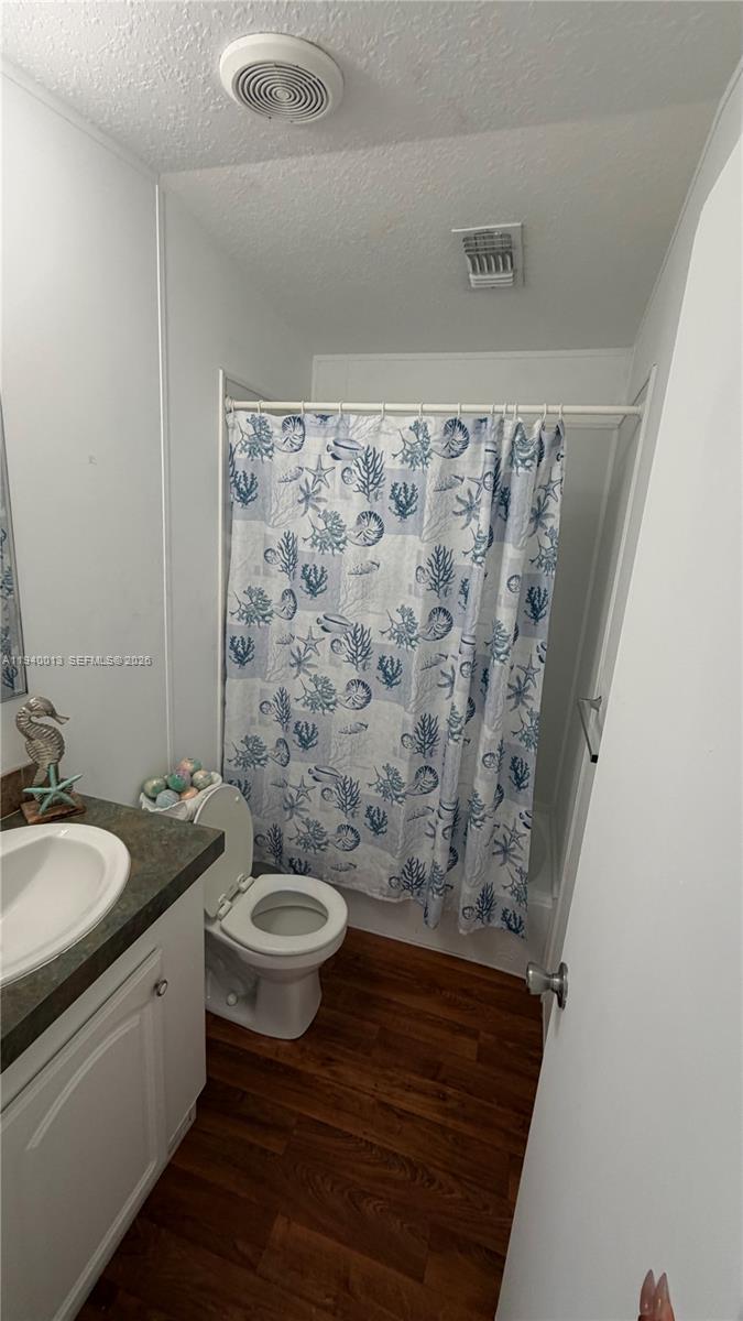 25345 Southwest 129th Place Homestead, FL 33032 - Photo 12 of 35 a bathroom with a granite countertop sink a toilet a mirror and shower curtain