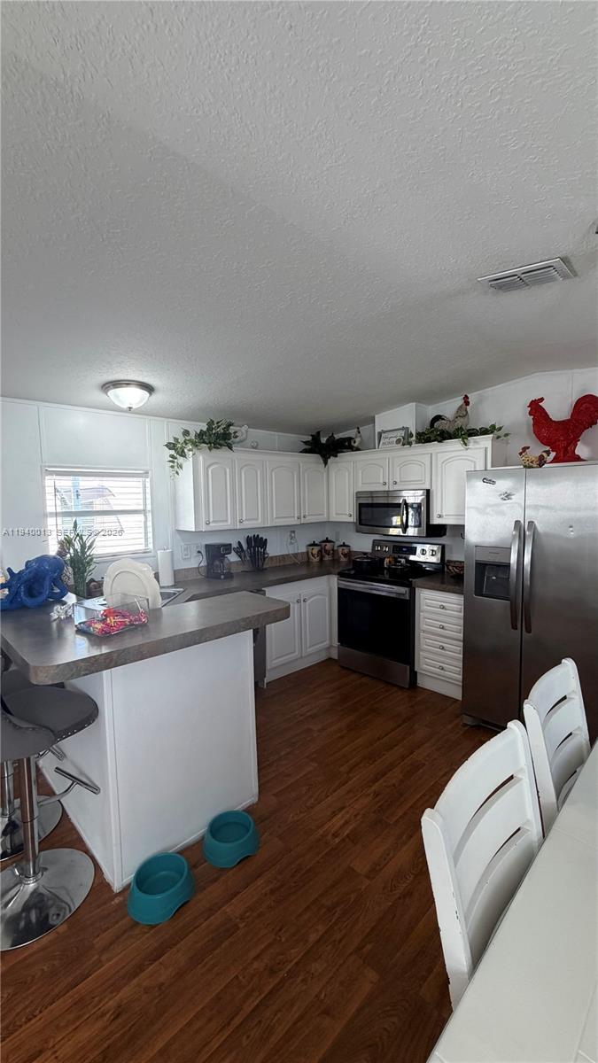 25345 Southwest 129th Place Homestead, FL 33032 - Photo 13 of 35 a kitchen with stainless steel appliances granite countertop a sink dishwasher stove top oven and cabinets with wooden floor