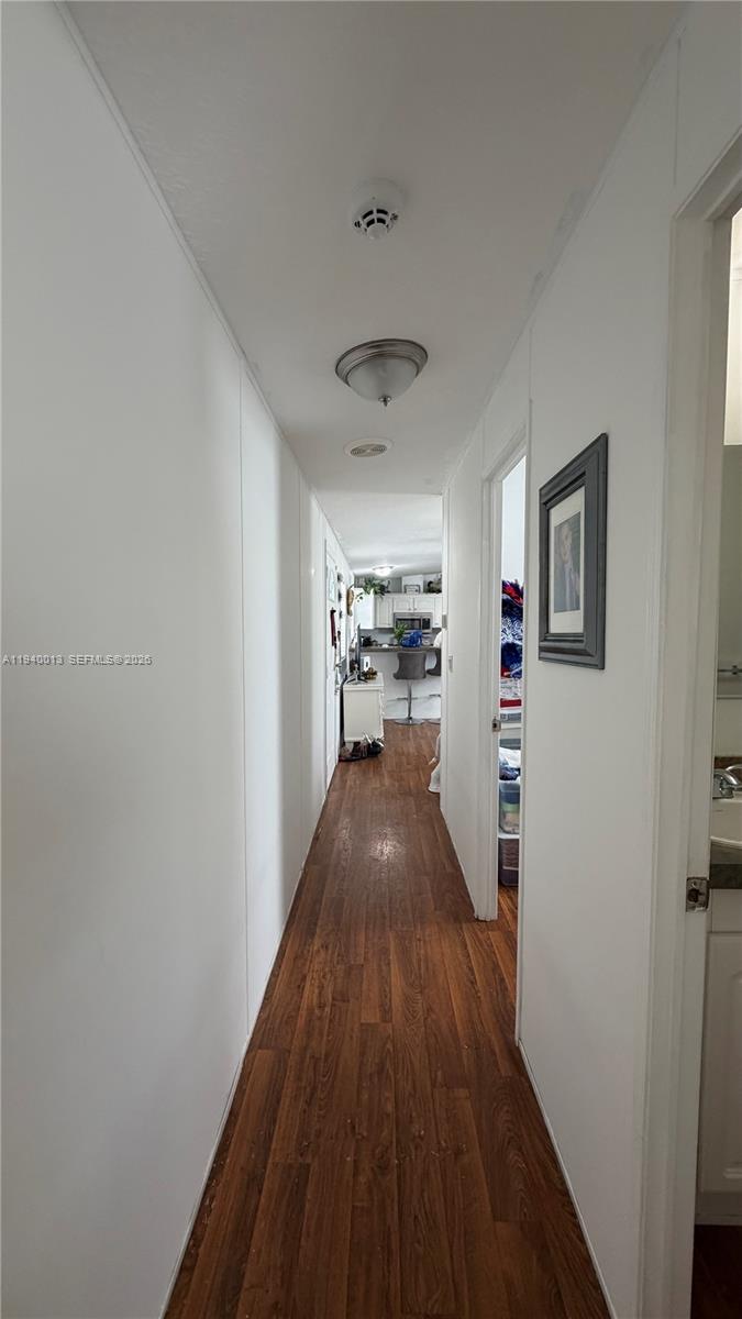 25345 Southwest 129th Place Homestead, FL 33032 - Photo 15 of 35 a view of a hallway with wooden floor and a kitchen space