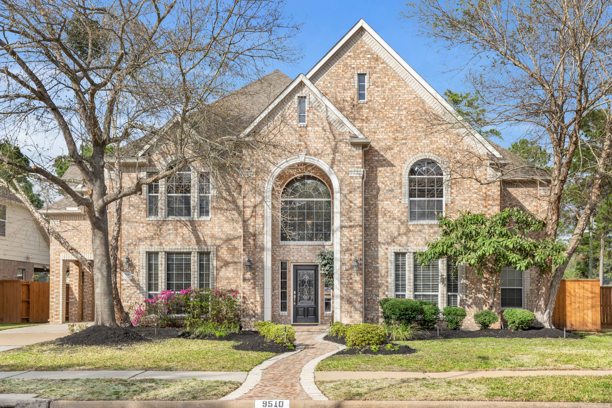 9510 Ashdown Forest Drive Spring, TX 77379 - Photo 3 of 50 Stately two-story brick elevation featuring a dramatic arched entry and large windows that fill the home with natural light. The classic architecture creates timeless curb appeal.