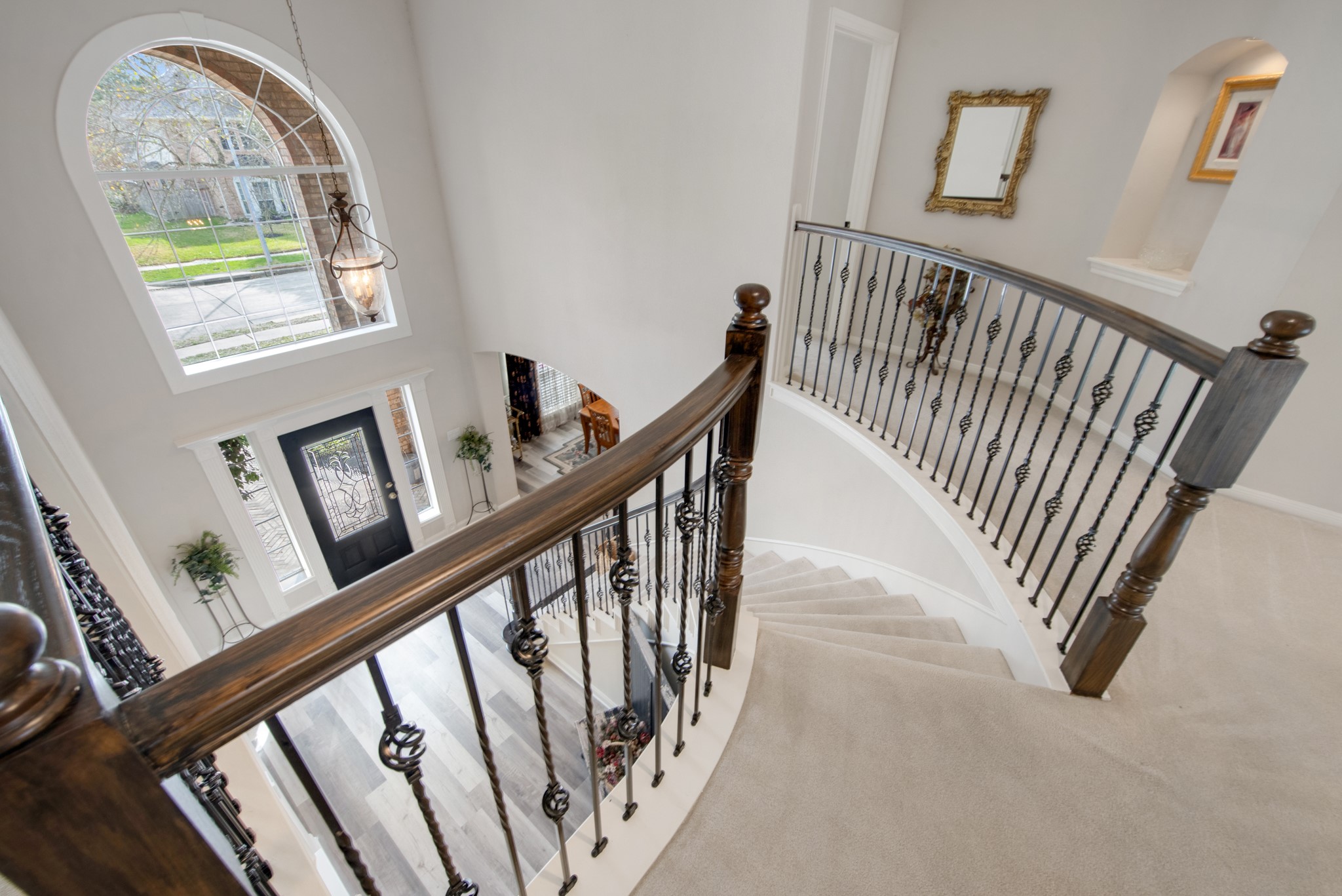 9510 Ashdown Forest Drive Spring, TX 77379 - Photo 33 of 50 CURVED STAIRCASE – elegant sweeping staircase with decorative iron balusters creates a dramatic architectural feature. The open design connects both levels beautifully.