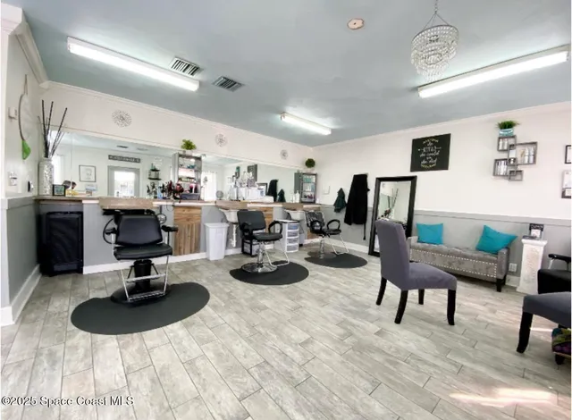 a living room with furniture a chandelier and kitchen view