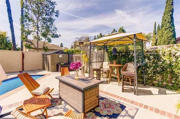 a view of a patio with table and chairs potted plants with wooden floor and fence