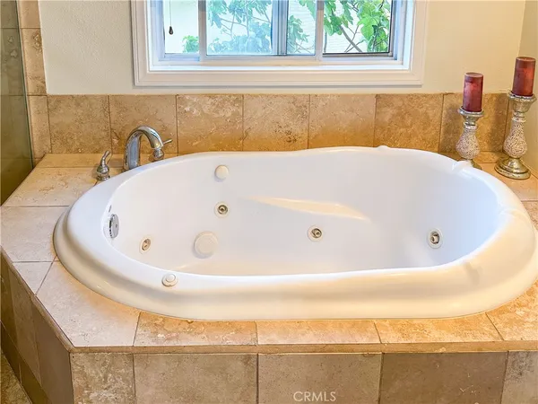 a white bath tub sitting in a bathroom next to a window