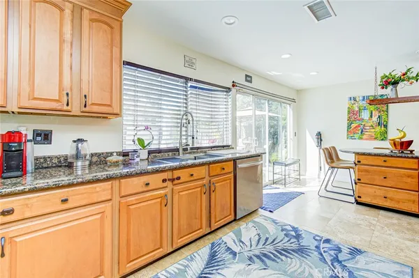 a kitchen with granite countertop a sink stainless steel appliances and cabinets