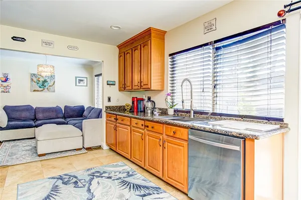 a large white kitchen with granite countertop a sink and a stove