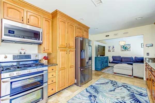 a kitchen with stainless steel appliances granite countertop a refrigerator and a stove top oven
