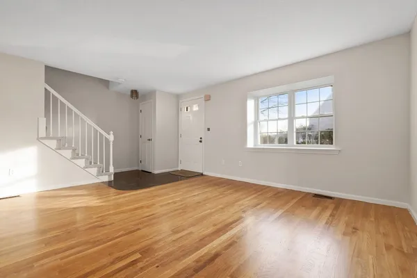 a view of a hallway with wooden floor and staircase