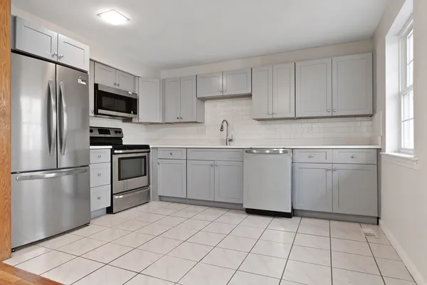a kitchen with stainless steel appliances a refrigerator sink and microwave