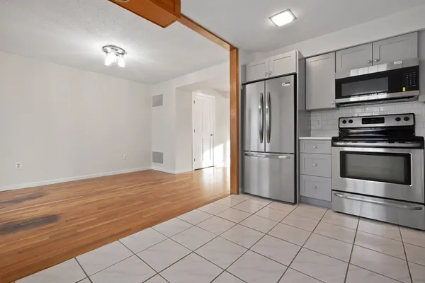 a large kitchen with cabinets and wooden floor