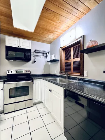 a kitchen with stainless steel appliances a stove a sink and a microwave