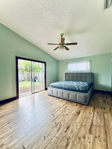 a living room with a bed and wooden floor