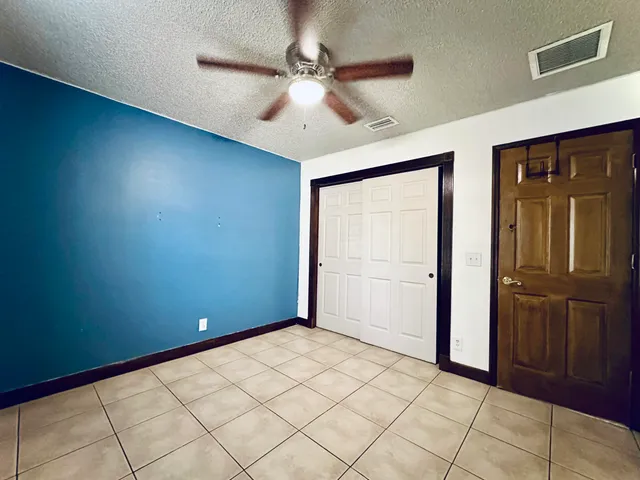 an empty room with closet and fan
