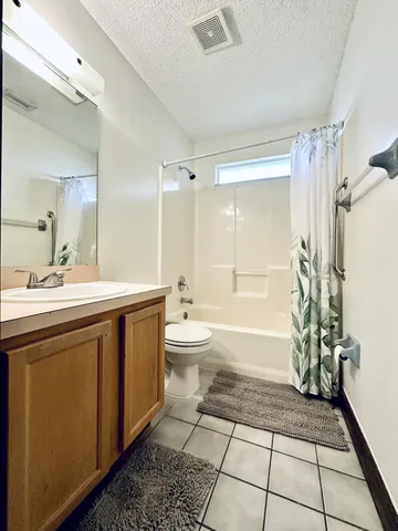 a spacious bathroom with a double vanity sink a toilet and a shower