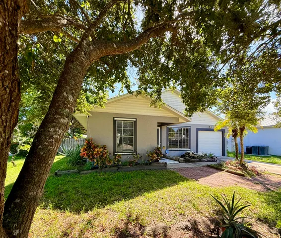 a view of a house with backyard and sitting area