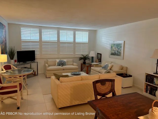 a living room with furniture a flat screen tv and a window