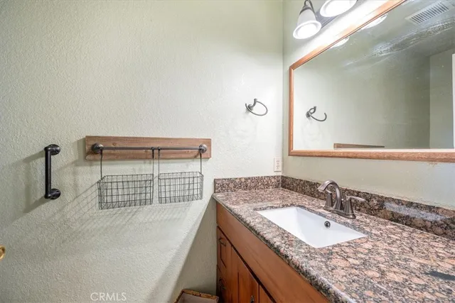 a bathroom with a granite countertop sink and a mirror