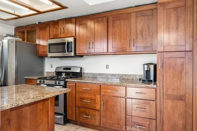 a kitchen with stainless steel appliances granite countertop a refrigerator sink and cabinets