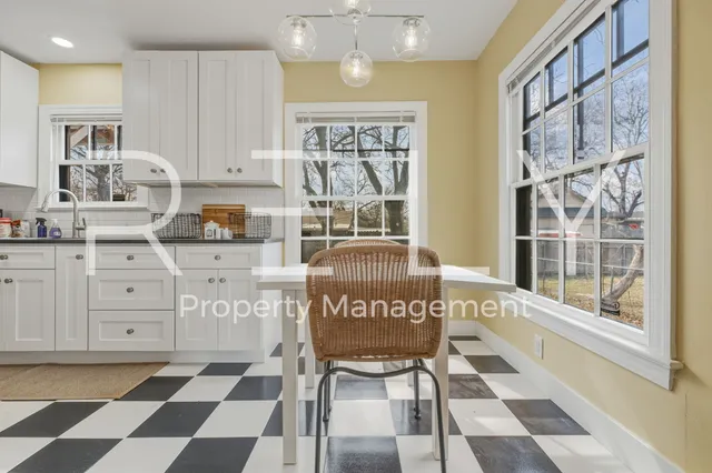 a kitchen with a stove a sink and a dining table chair