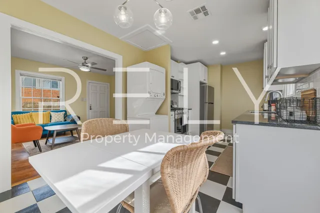 a living room with furniture kitchen view and a wooden floor