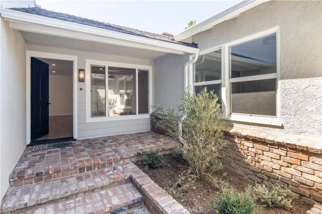 a view of kitchen with kitchen island a sink wooden floor and a refrigerator