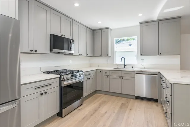 a kitchen with a refrigerator sink and cabinets