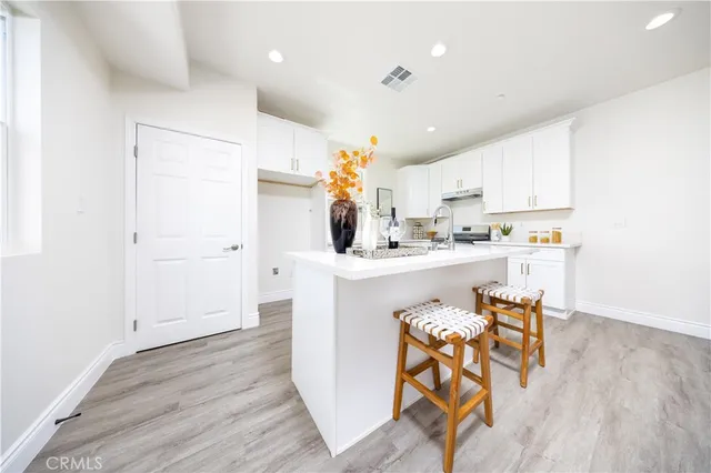 a kitchen with a table chairs refrigerator and microwave