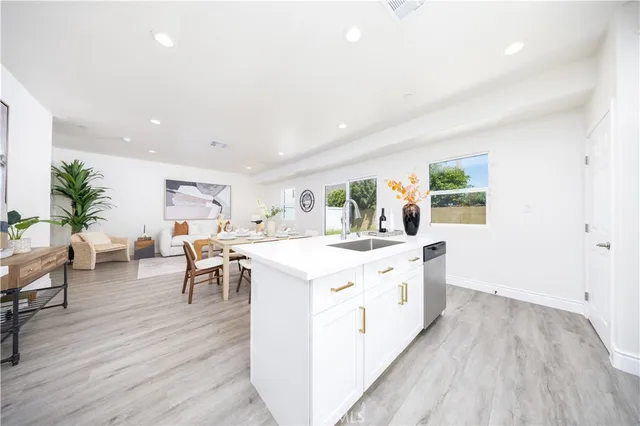 a large living room with stainless steel appliances granite countertop a lot of counter space and wooden floor