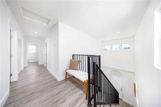 a view of a hallway with wooden floor and staircase