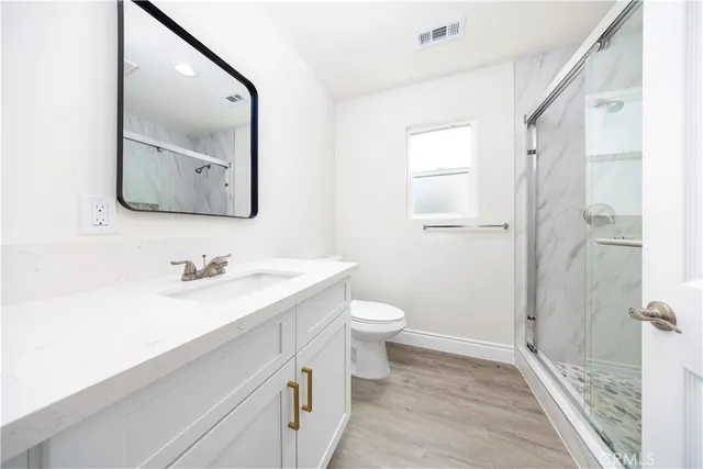 a bathroom with a sink a toilet and shower