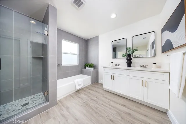 a spacious bathroom with a double vanity sink a mirror and shower