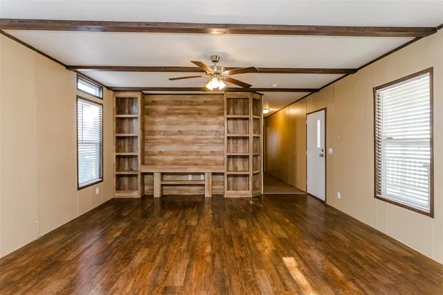 a view of a livingroom with wooden floor and a ceiling fan