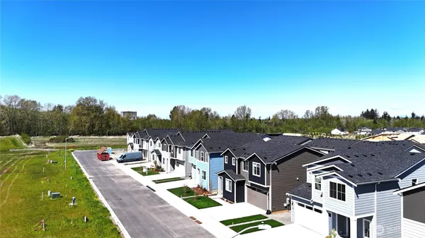 a view of a big house with a big yard and large trees