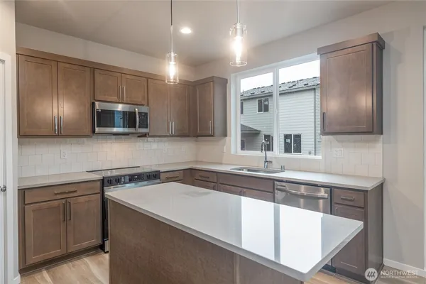 a kitchen with a sink and stainless steel appliances