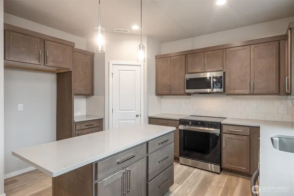 a kitchen with stainless steel appliances a stove microwave and sink