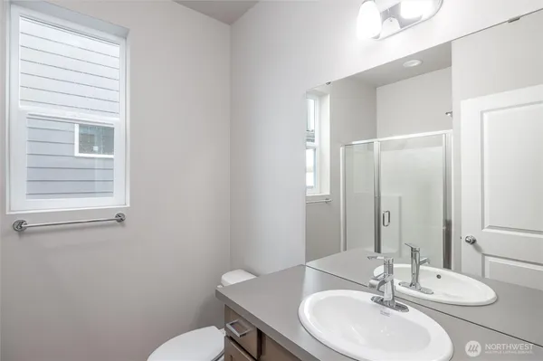 a bathroom with a granite countertop sink toilet and mirror