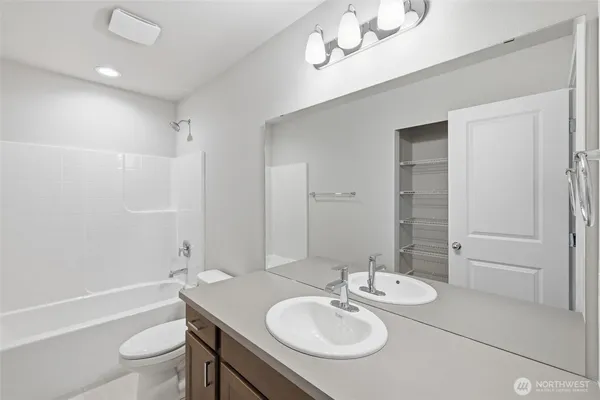 a bathroom with a sink a toilet a mirror and shower