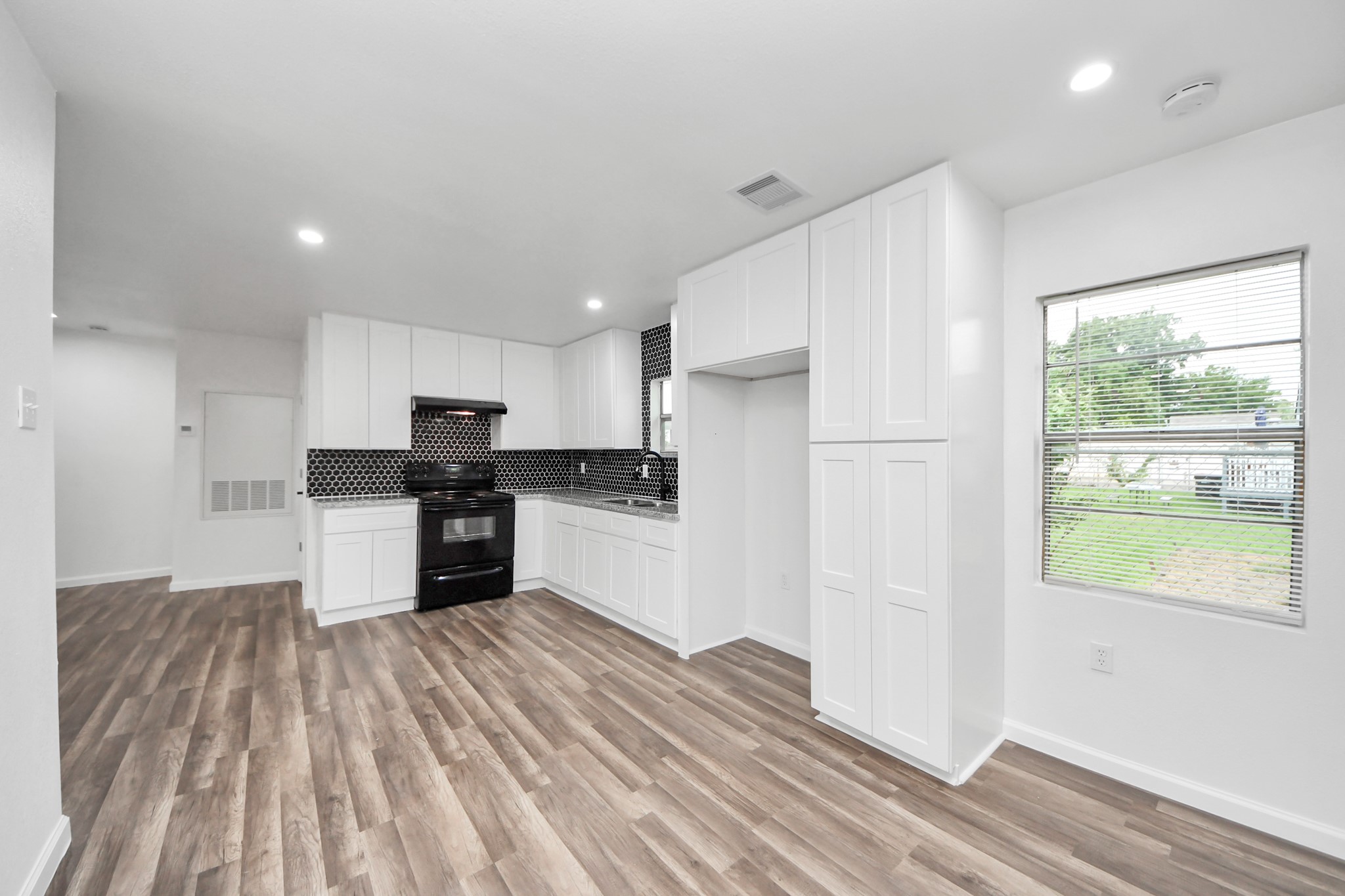 207 East Defee Avenue Baytown, TX 77520 - Photo 18 of 36 a kitchen with stainless steel appliances kitchen island granite countertop a refrigerator and a stove top oven