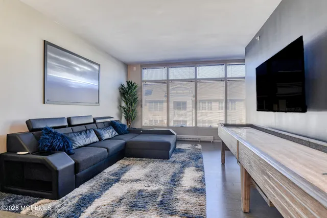 a living room with furniture a flat screen tv and a large window