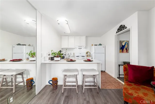 a view of kitchen with refrigerator and wooden floor