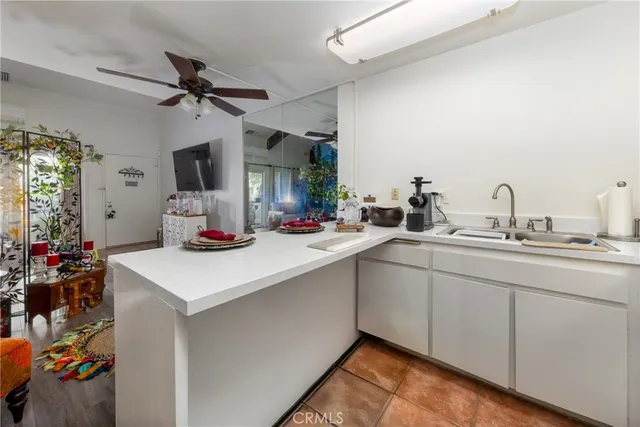 a kitchen with a sink dishwasher and a stove with wooden floor