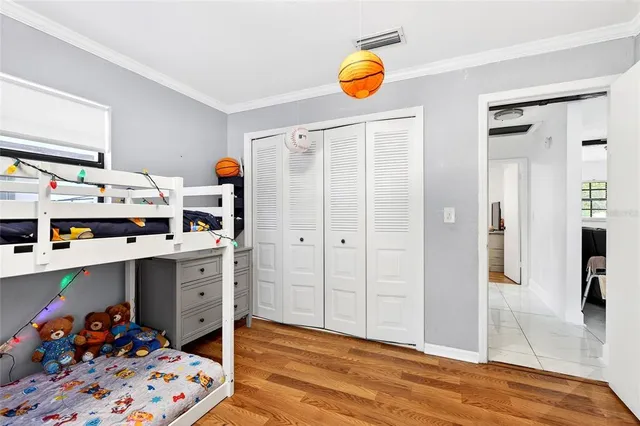 a view of a bedroom with baby bed and workspace